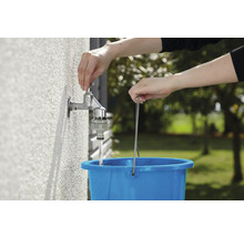 Wasserhahn wird aufgedreht, um einen blauen Eimer zu füllen