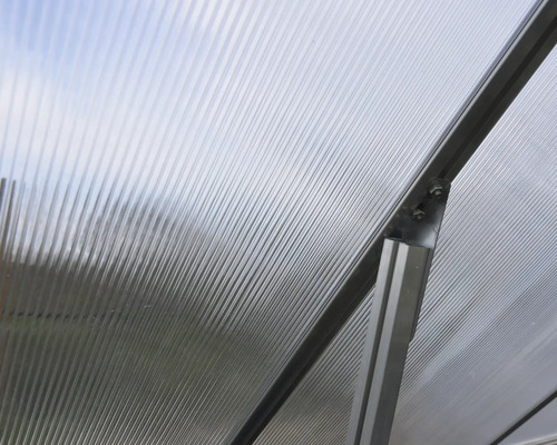 Vue détaillée d''une construction de serre avec des plaques alvéolaires transparentes et un cadre métallique