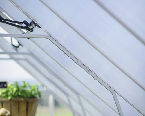 Vue intérieure d''une serre avec des panneaux transparents et une structure métallique