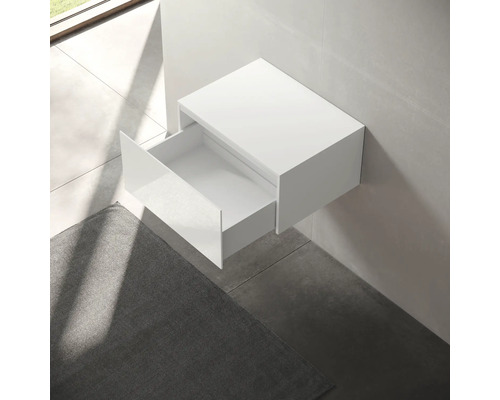 Meuble sous-vasque blanc avec tiroir ouvert, monté au mur