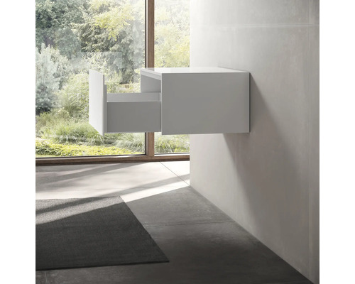 Meuble sous-lavabo blanc avec tiroir ouvert dans une salle de bains