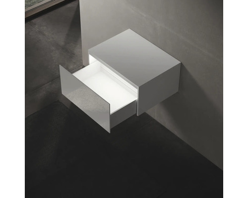 Meuble sous-vasque suspendu avec tiroir ouvert dans la salle de bains.