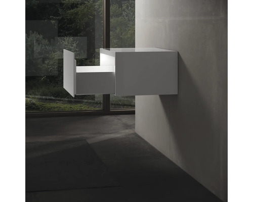 Meuble sous-vasque suspendu blanc avec tiroir ouvert dans la salle de bain