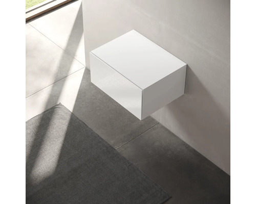 Meuble bas suspendu blanc dans la salle de bain.