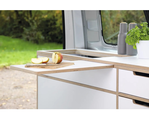 Campingausbau mit Ausziehtisch, Schneidebrett, Messer und Apfel