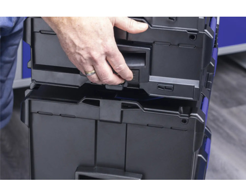 Coffres à outils empilés avec une main sur la poignée