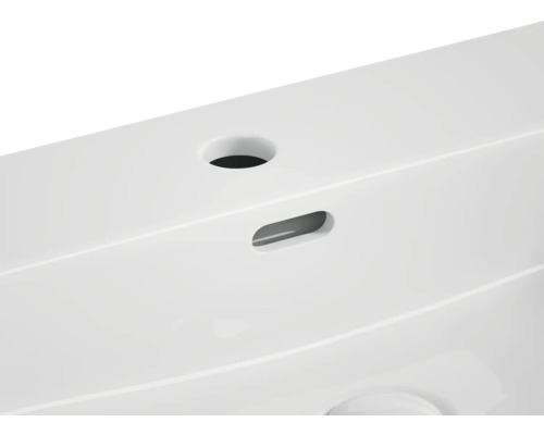 Detailansicht eines Waschbeckens mit Hahnloch und Überlauf