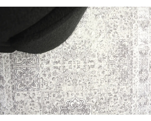 Detailansicht eines Teppichs mit Muster unter einem Möbelstück