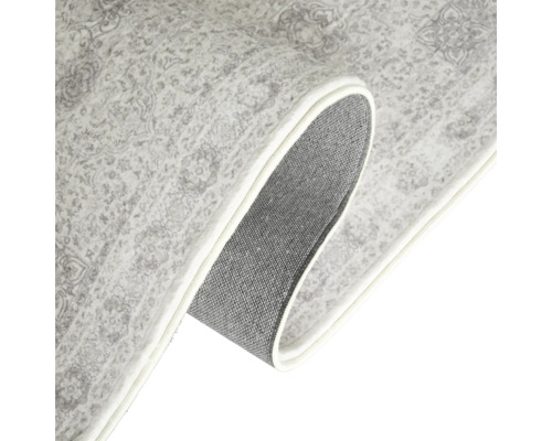 Detailansicht eines Teppichs mit gemustertem Design und Textilrücken.