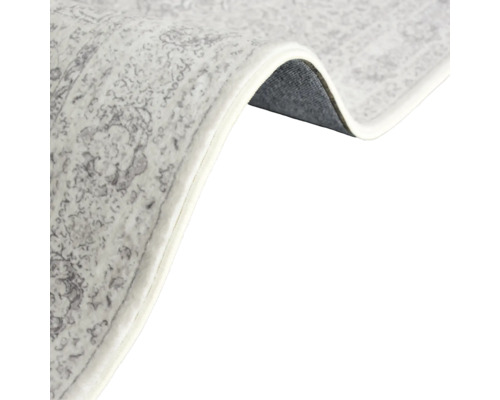 Detailansicht eines gemusterten Teppichs mit gekettelten Kanten.