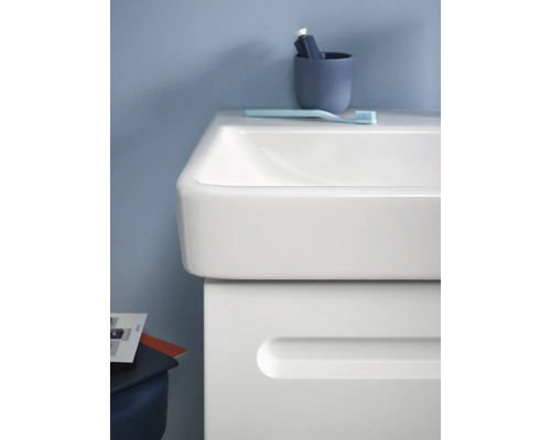 Gros plan d''une salle de bains avec lavabo, gobelet à brosse à dents et brosse à dents