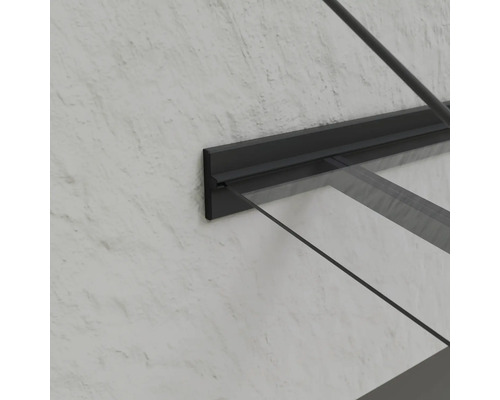 Detailansicht einer Glas-Haustürüberdachung mit dunklem Rahmen an einer Wand