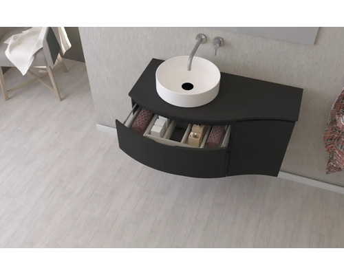 Salle de bains moderne avec meuble-lavabo noir, vasque à poser et élément de tiroir ouvert pour le rangement.
