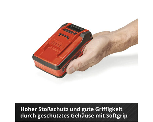 Ein roter Elektrowerkzeug-Akkumulator wird in der Hand gehalten.