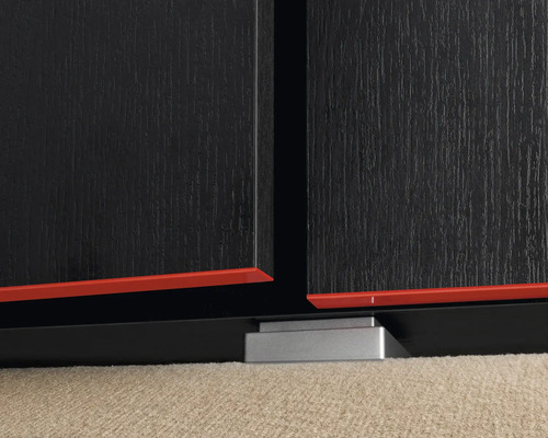 Detailansicht eines schwarzen Möbels mit roten Akzenten und silberfarbenen Füßen