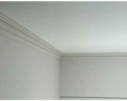 Eckansicht eines Raumes mit angebrachten Zierleisten an der Decke
