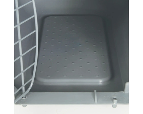 Vue intérieure d''une cage de transport pour animaux de compagnie avec porte grillagée et fond perforé