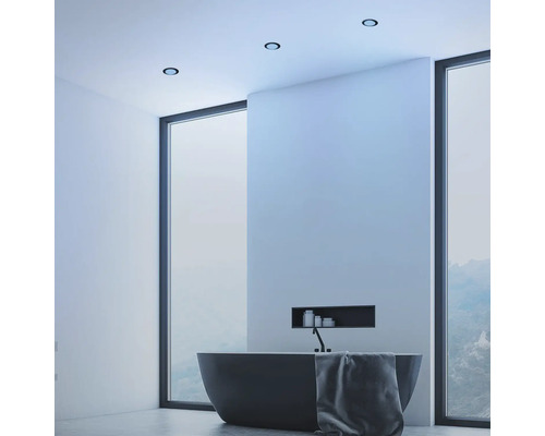 Salle de bain moderne avec baignoire îlot, spots de plafond et grande fenêtre