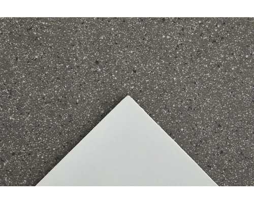 Gros plan d''un plan de travail avec une surface mouchetée et une plaque blanche