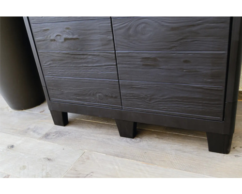 Gros plan d''une armoire en plastique noire avec aspect bois et pieds.