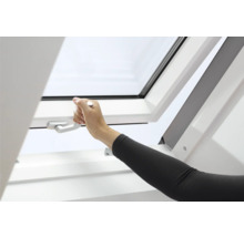 Eine Hand öffnet ein Dachfenster mit einem Griff.