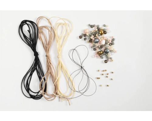 Différents cordons de bijoux et perles de bijoux sur fond clair.