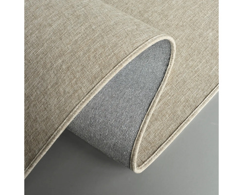 Detailansicht eines beigefarbenen Teppichs mit gewebter Textur