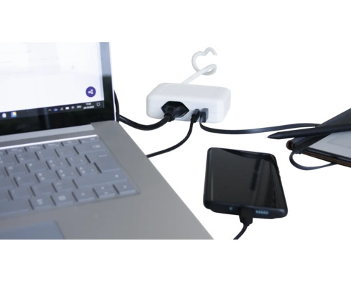 Mehrfachsteckdose mit angeschlossenen elektronischen Geräten wie Laptop und Smartphone
