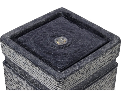 Gros plan d''une fontaine de jardin carrée avec éclairage