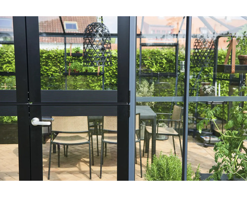 Gewächshaus mit Sitzgelegenheit und Dekoration im Garten