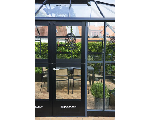 Serre avec portes en verre et logo Juliana. À l''intérieur, il y a une table à manger avec des chaises.
