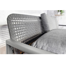 Detailansicht eines Outdoor-Sessels mit Rattangeflecht und Kissen