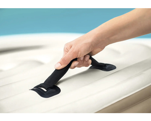 Une personne tient la poignée d''un matelas pneumatique