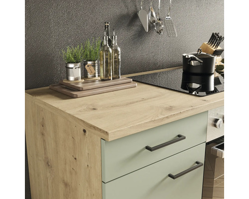 Scène de cuisine avec plan de travail, évier, plaque de cuisson, casserole et ustensiles de cuisine.