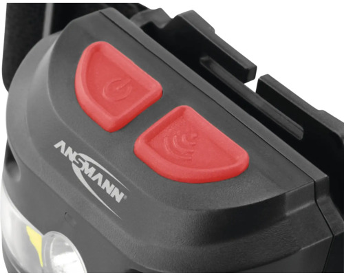 Gros plan d''une lampe frontale avec le logo Ansmann et deux boutons : bouton marche/arrêt et commande gestuelle