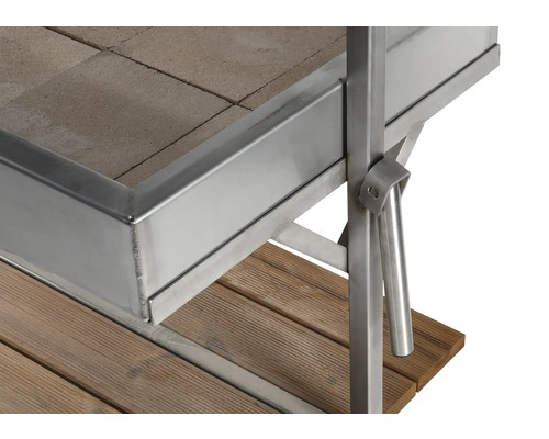 Detailansicht eines Grills mit Steinfliesen, Metallrahmen und Holzuntergrund