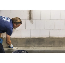 Handwerker trägt Putz auf Wand auf