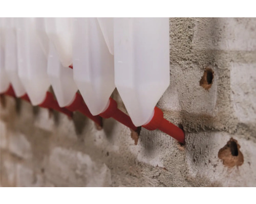 Automatische Tränke für Geflügel an einer Wand befestigt