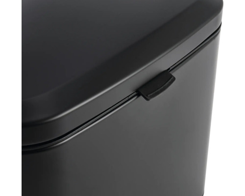 Detailansicht eines schwarzen Abfalleimers mit Deckel und Verschlussmechanismus.