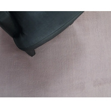 Detailaufnahme eines schwarzen Möbelfußes auf einem weichen Teppich