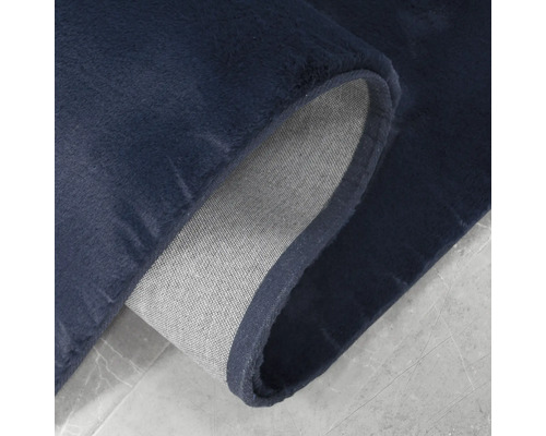 Gros plan d''un tapis bleu foncé avec envers textile