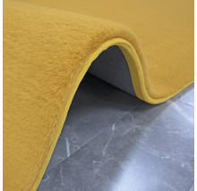 Tapis jaune à poils sur fond gris