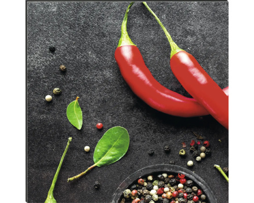 Zwei rote Chilischoten und Pfefferkörner in einer Schale.