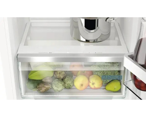 Intérieur d''un réfrigérateur avec bac à légumes, casserole et bouteille