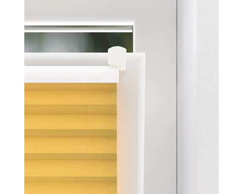 Nahaufnahme eines gelben Plissees am Fenster