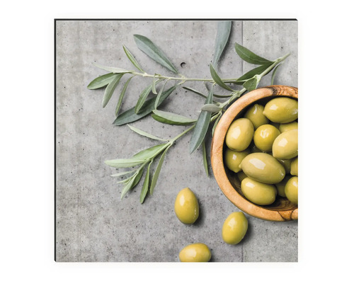 Nature morte avec des olives dans un bol en bois et une branche d''olivier sur fond béton