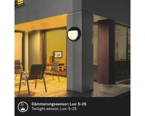 Aussenbereich mit einer runden Wandleuchte an einem Pfeiler