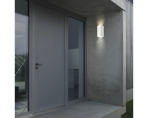 Eine Aussenwandleuchte ist neben einer Tür montiert.