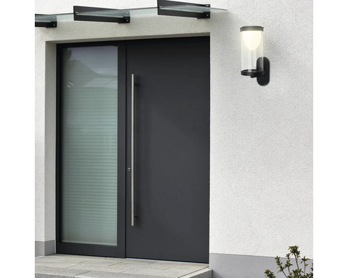 Haustür mit Seitenteil, Vordach und Aussenleuchte an einer weissen Wand.