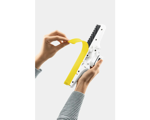 Une personne change la lèvre en caoutchouc d''un aspirateur de fenêtre.